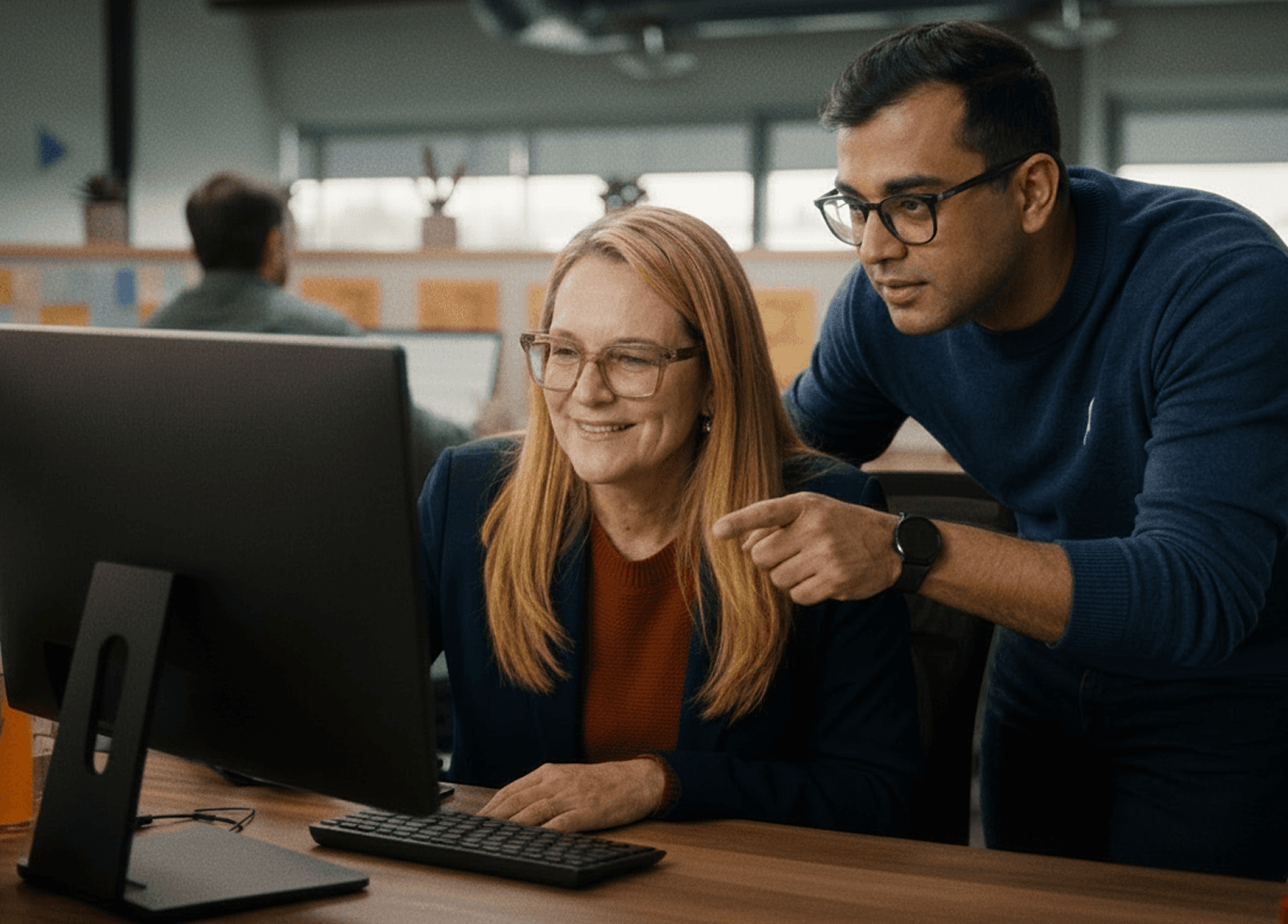 Two colleagues reviewing fleet data together at a desktop workstation